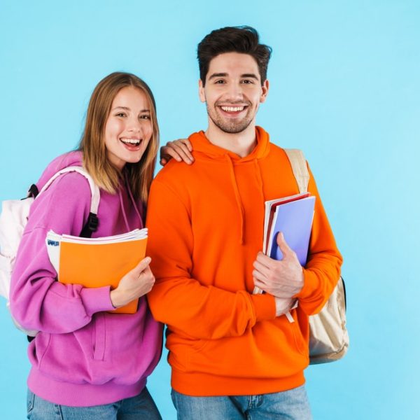 Portrait,Of,A,Cheerful,Young,Couple,Of,Students,Wearing,Backpacks,